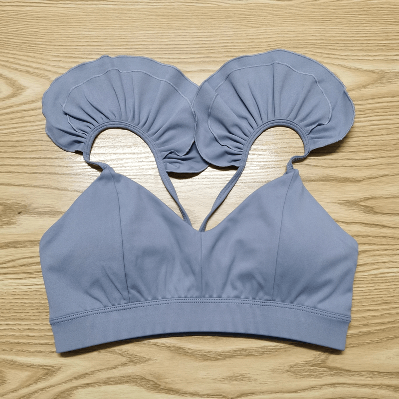 Stylish blue quick dry sports bra with unique ruffled straps, perfect for yoga, running, and more. Breathable, nylon material for comfort.
