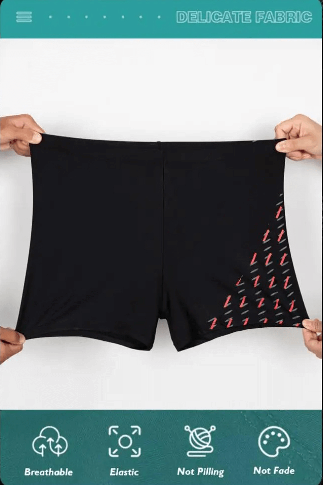 Black quick dry swim trunks with vibrant red pattern held by two hands, showcasing breathable and elastic qualities, marked as delicate fabric.