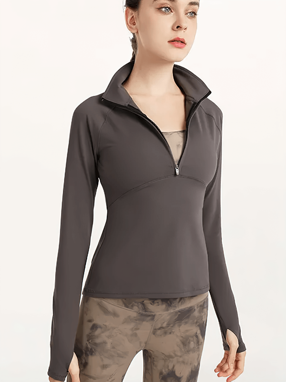 Woman wearing a quick-dry long sleeve yoga shirt with half-zip, made from breathable nylon and spandex. Ideal for fitness and running.