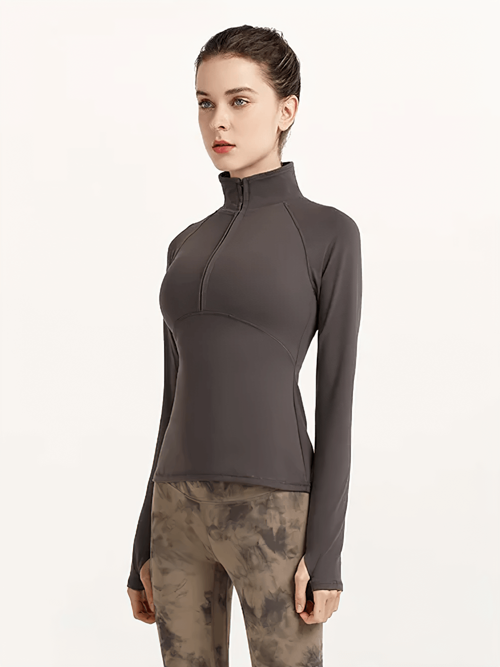 Woman wearing a dark gray quick-dry yoga shirt with long sleeves and half-zip, ideal for fitness and running.