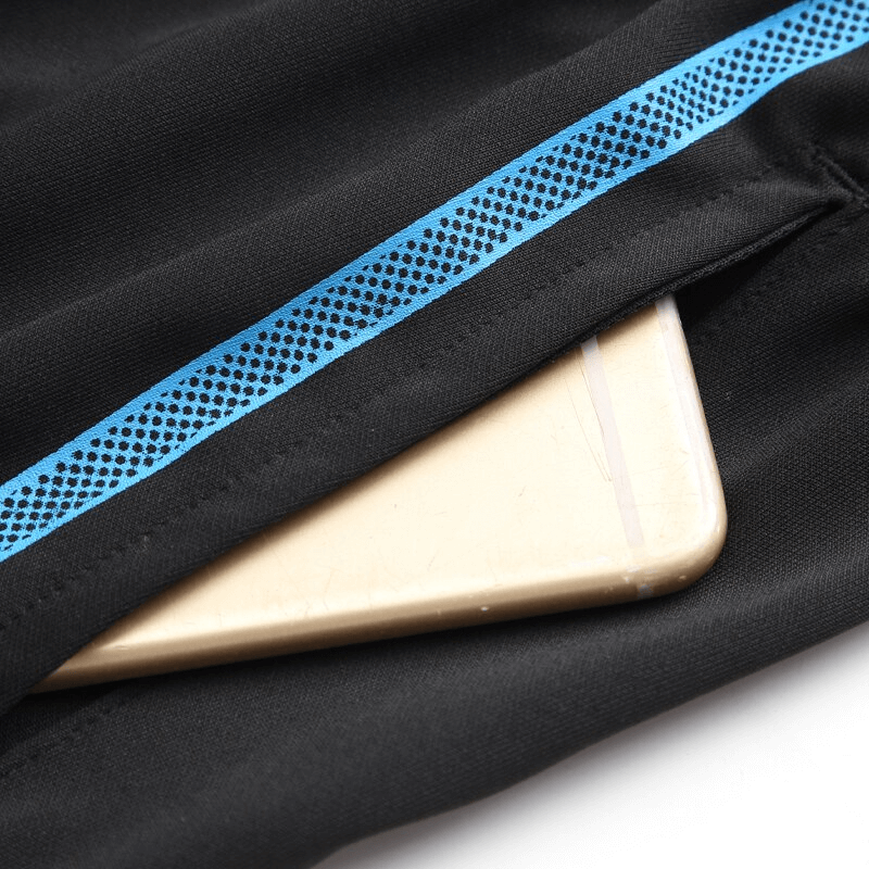 Smartphone peeks out from the side pocket of black quick-drying sports men's shorts with blue trim, highlighting convenience and style.