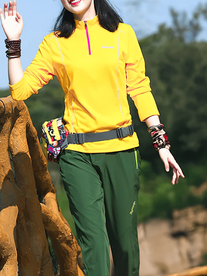 Woman wearing a quick-drying yellow top with stand-up collar and half zip, perfect for active lifestyles and outdoor adventures.