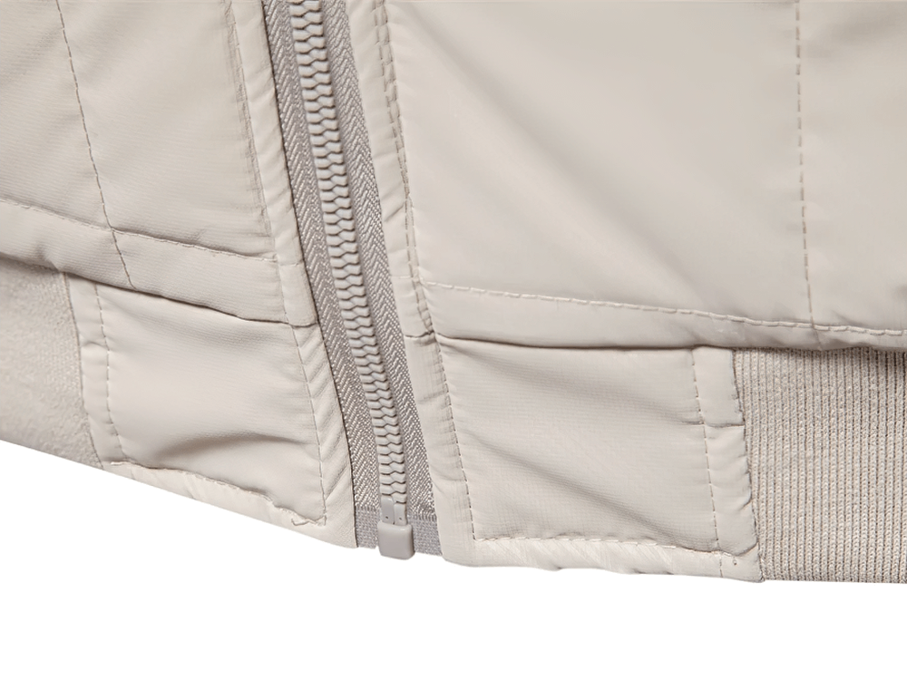 Close-up of quilted jacket with textured sleeves and zipper, showcasing durable stitching and sleek design for warmth and style.