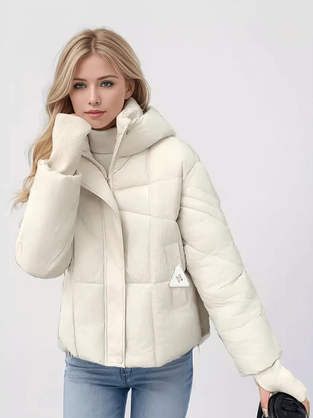 Woman wearing a chic beige quilted hooded jacket with ribbed cuffs, showcasing winter style and warmth.