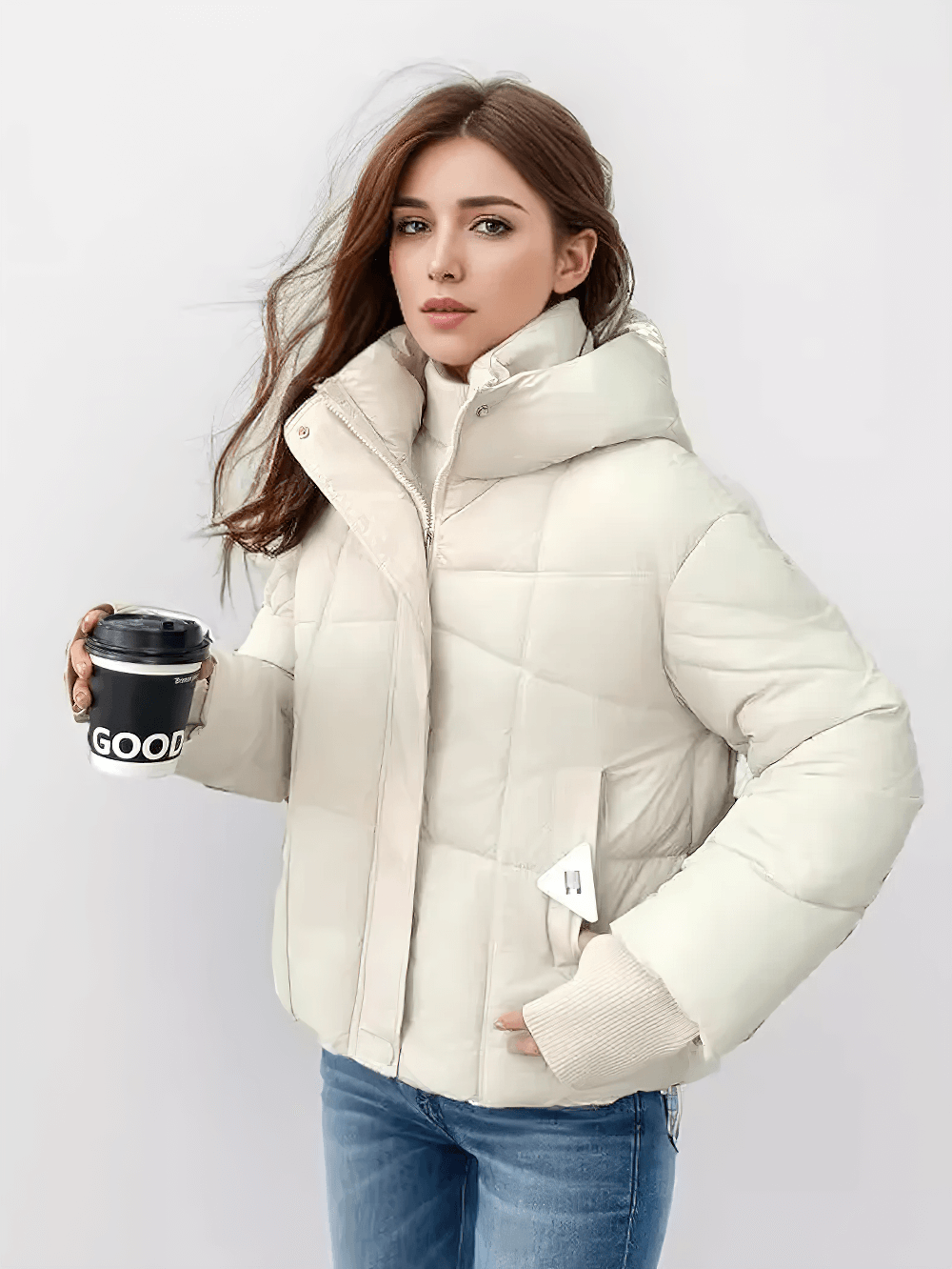 Woman wearing chic beige quilted jacket with hood and ribbed cuffs, holding a coffee cup. SF2304 stylish winter outerwear.