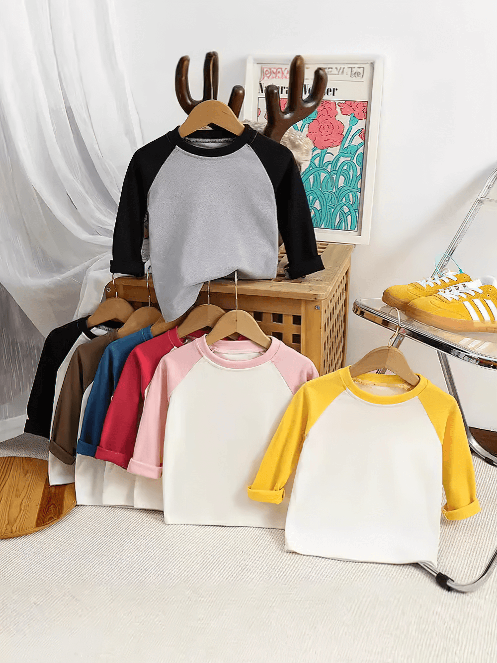 Colorful raglan sleeves cute tops for kids with round neck, displayed on hangers, highlighting multiple styles and colors.