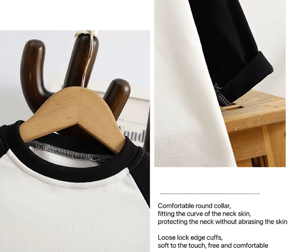 Black and white raglan sleeve top for kids with a soft round neck collar, displayed on a wooden hanger. Perfect for comfort and style.