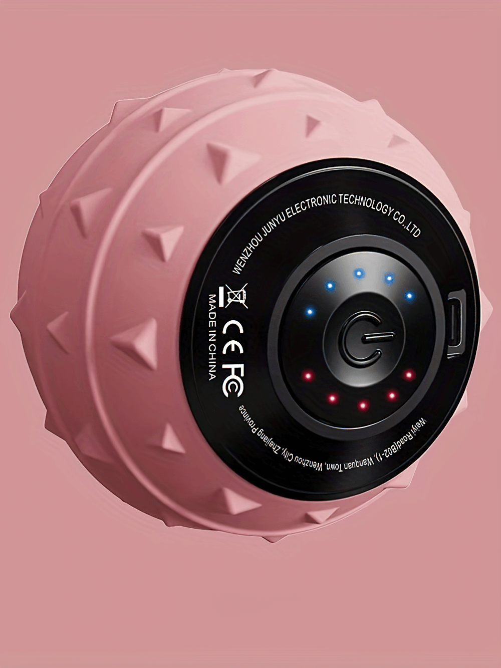 Rechargeable pink vibrating massage ball with textured surface for muscle recovery and therapy.