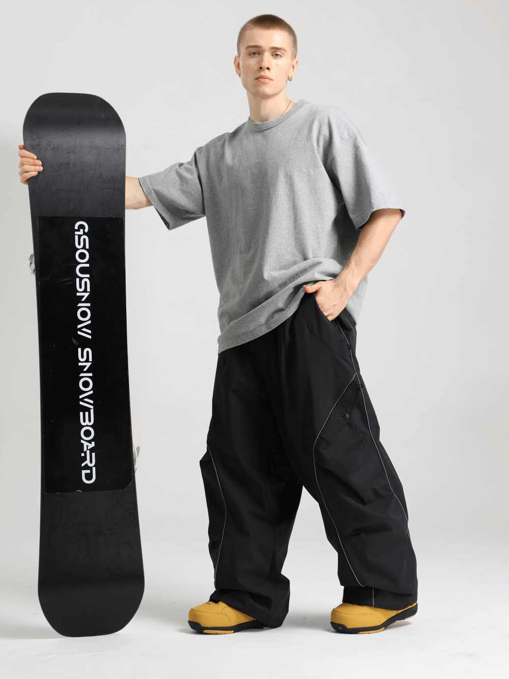 Person wearing Reflective Stripe Baggy Snowboard Ski Pants - SF4247 holding a snowboard against a plain background.