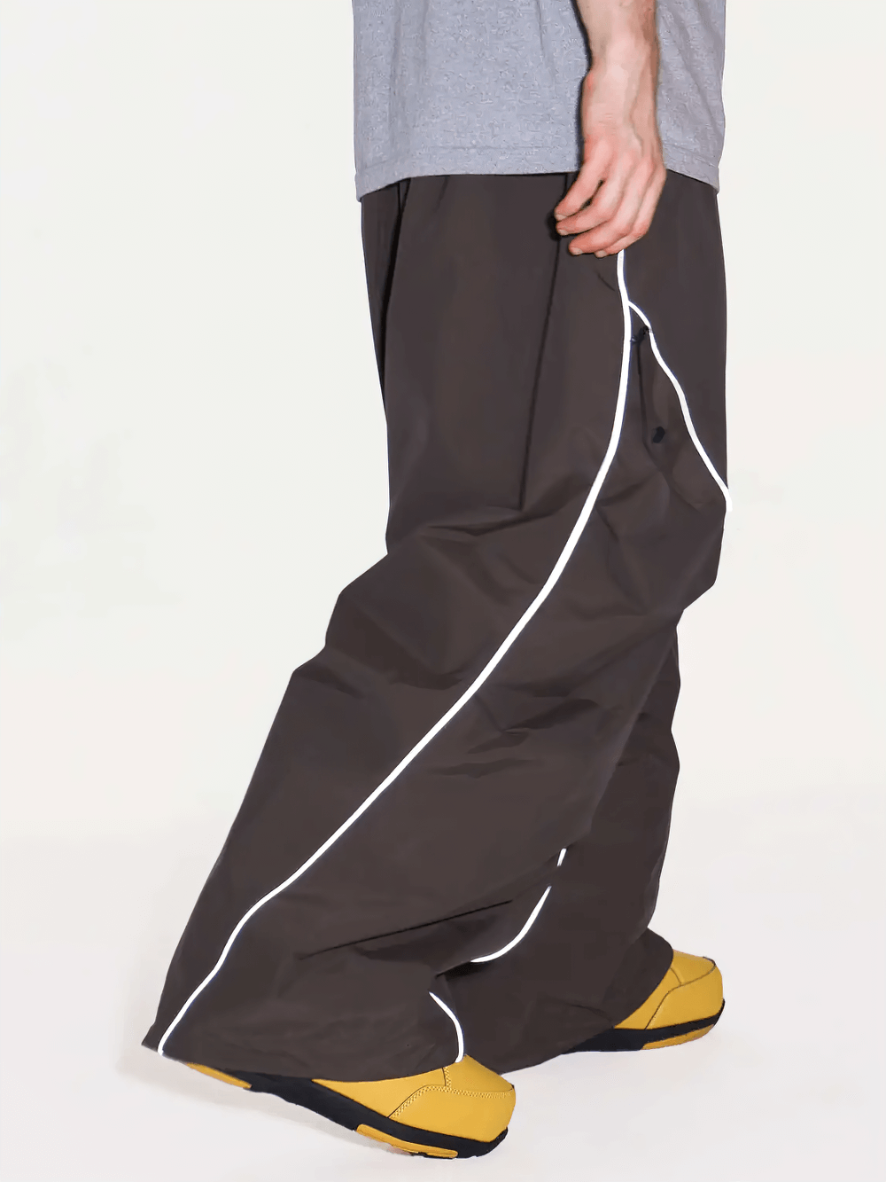 Side view of Reflective Stripe Baggy Snowboard Ski Pants - SF4247 with yellow boots, highlighting the reflective stripe detail.