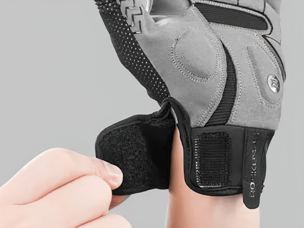 Close-up of reflective touchscreen cycling glove being fastened, showing SBR padding and non-slip silicone strips for optimal grip.