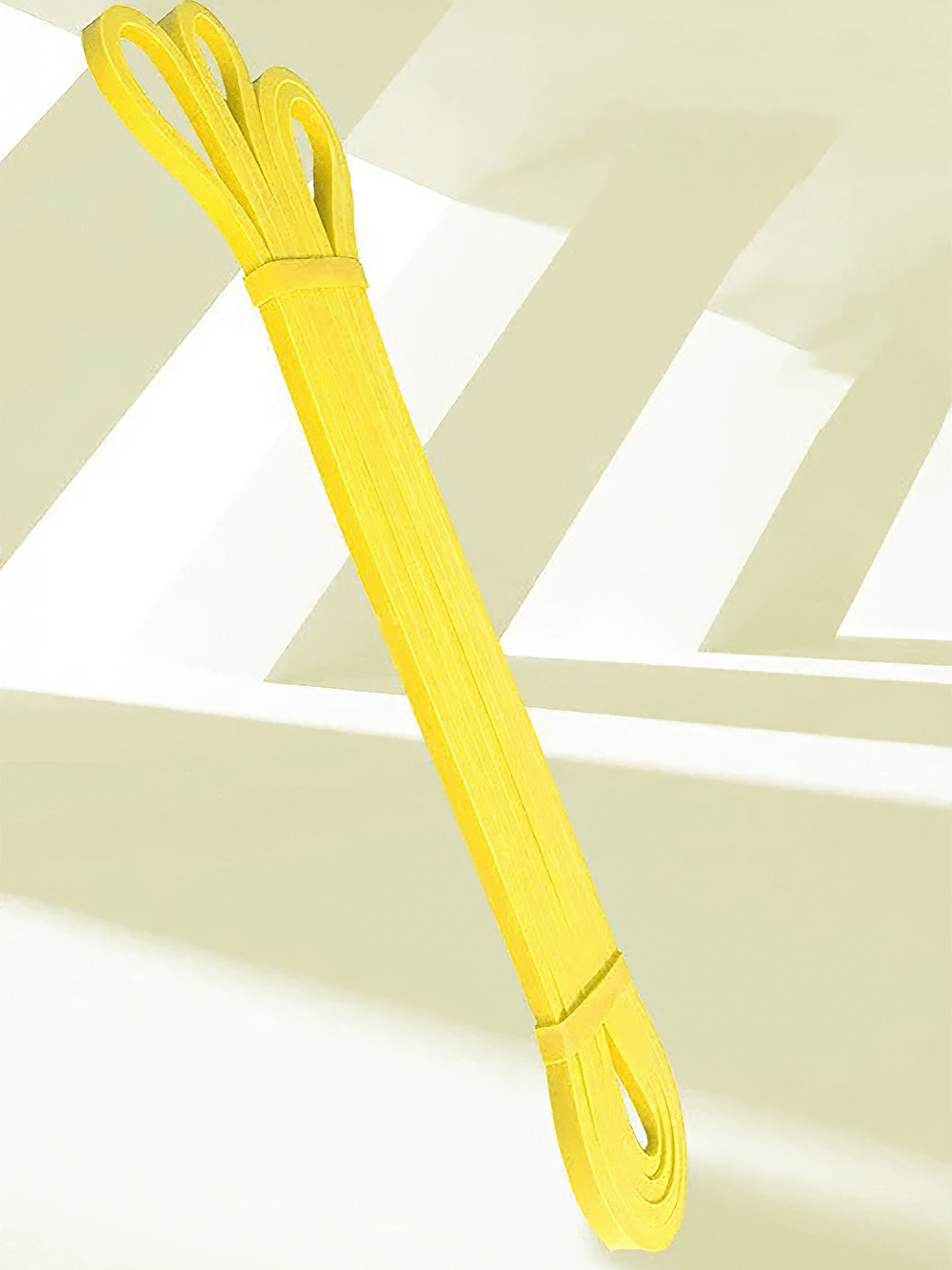 Bright yellow resistance band for pull ups and stretching, perfect for home workouts and physical therapy. Durable and versatile fitness tool.