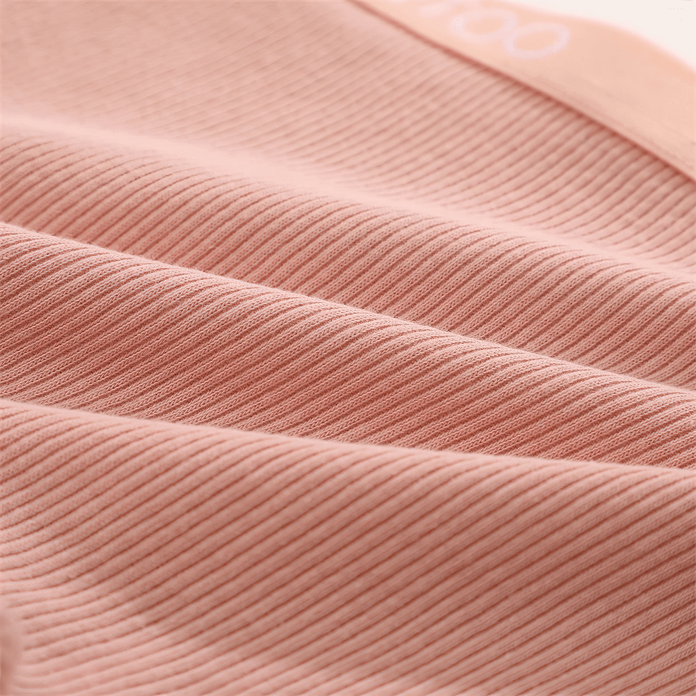 Close-up of ribbed boyshort panties fabric in soft pink, highlighting stretch and texture for comfortable wear.