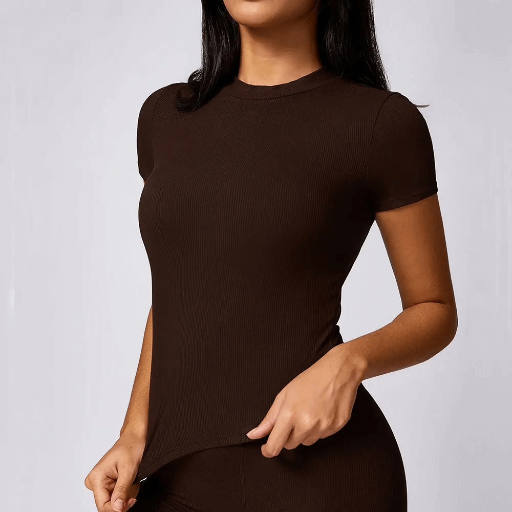 Woman wearing a ribbed short sleeve yoga crop T-shirt in black, showcasing quick-dry and breathable features for fitness enthusiasts.