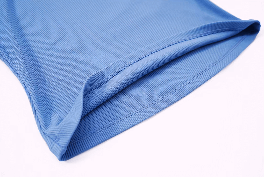 Close-up of blue ribbed short sleeve yoga crop top showing fabric texture and stitching detail.