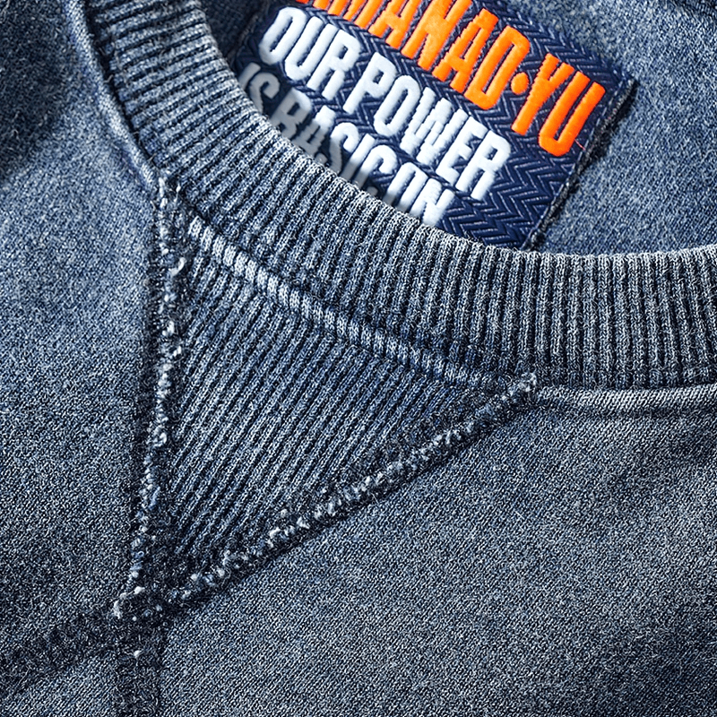 Close-up of a round neck, long-sleeved knitted sports pullover in thick cotton for men, featuring an intricate stitching detail.