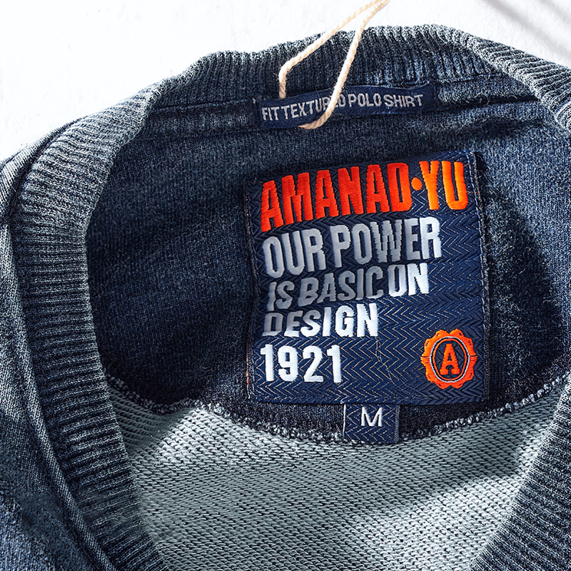 Close-up of knitted sports pullover label with 'AMANAD-YU' design details, showcasing medium size and unique style.