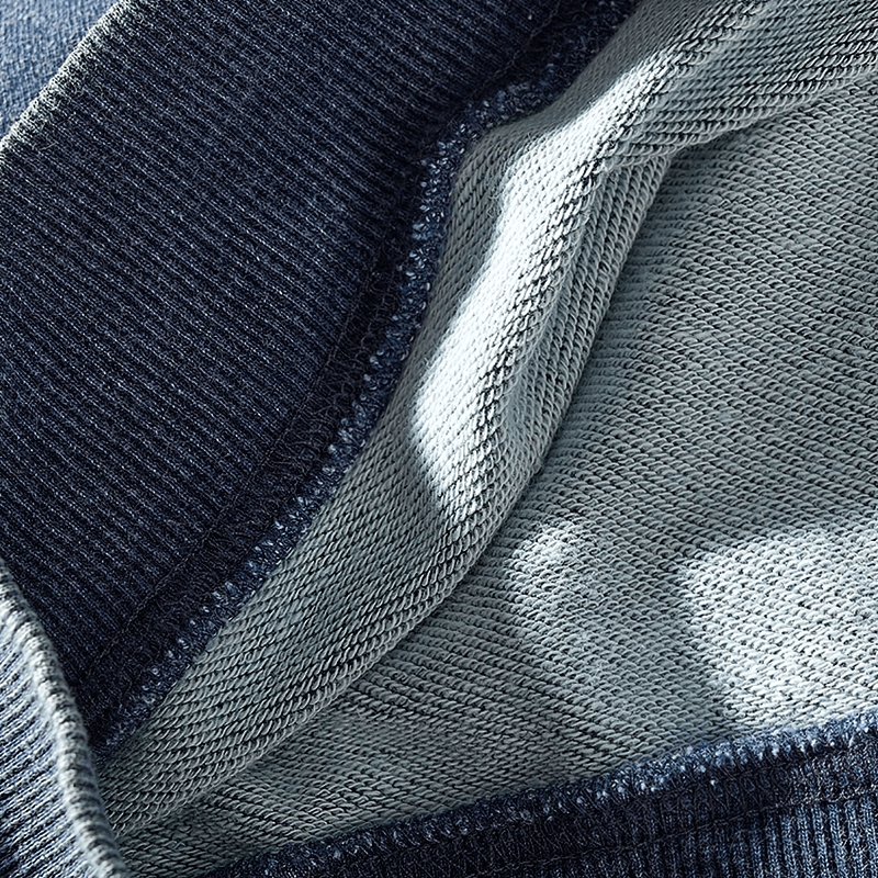 Close-up of a grey and black knitted sports pullover for men highlighting texture and stitching details.