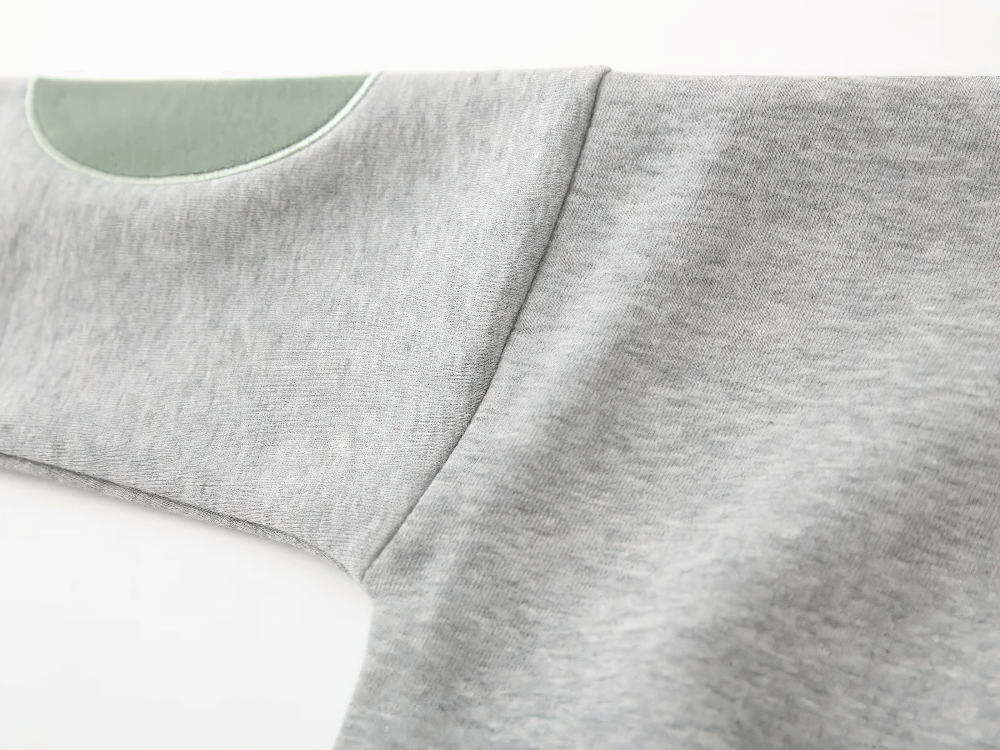 Close-up of Round Neck Sweatshirt with Contrasting Sleeves - SF3550 in grey with green patch on sleeve for kids' active play.