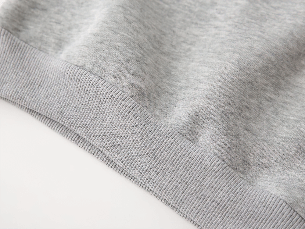 Close-up of Round Neck Sweatshirt with Contrasting Sleeves - SF3550 showing ribbed hem detail in soft gray cotton blend.