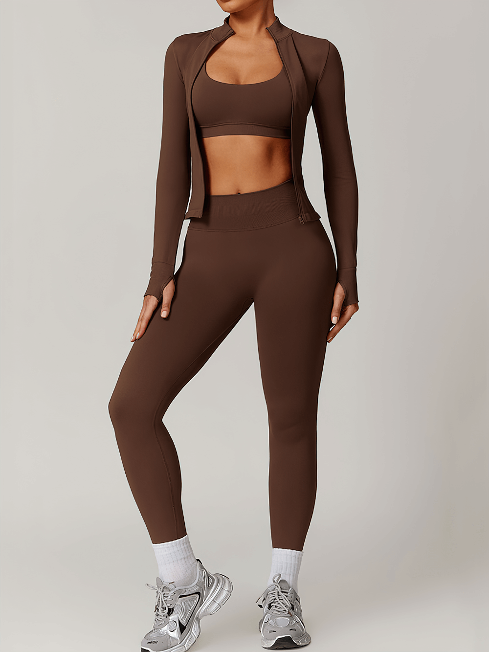 Woman wearing a seamless brown activewear set with thumbholes, high-waist leggings, and zip-up top, ideal for workout or casual wear.