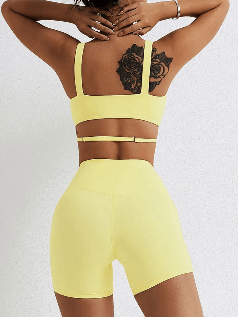 Back view of yellow seamless gym sports suit with bra and shorts, featuring breathable nylon-spandex blend for yoga and fitness.