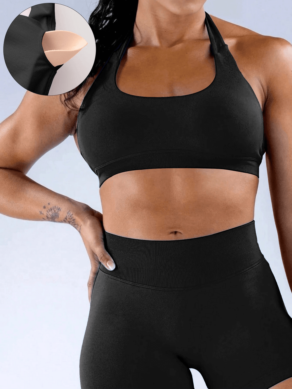 Woman wearing Seamless Halter Neck Sports Bra with Padded Cups - SF4064 in black showcasing open back design and smooth fabric.