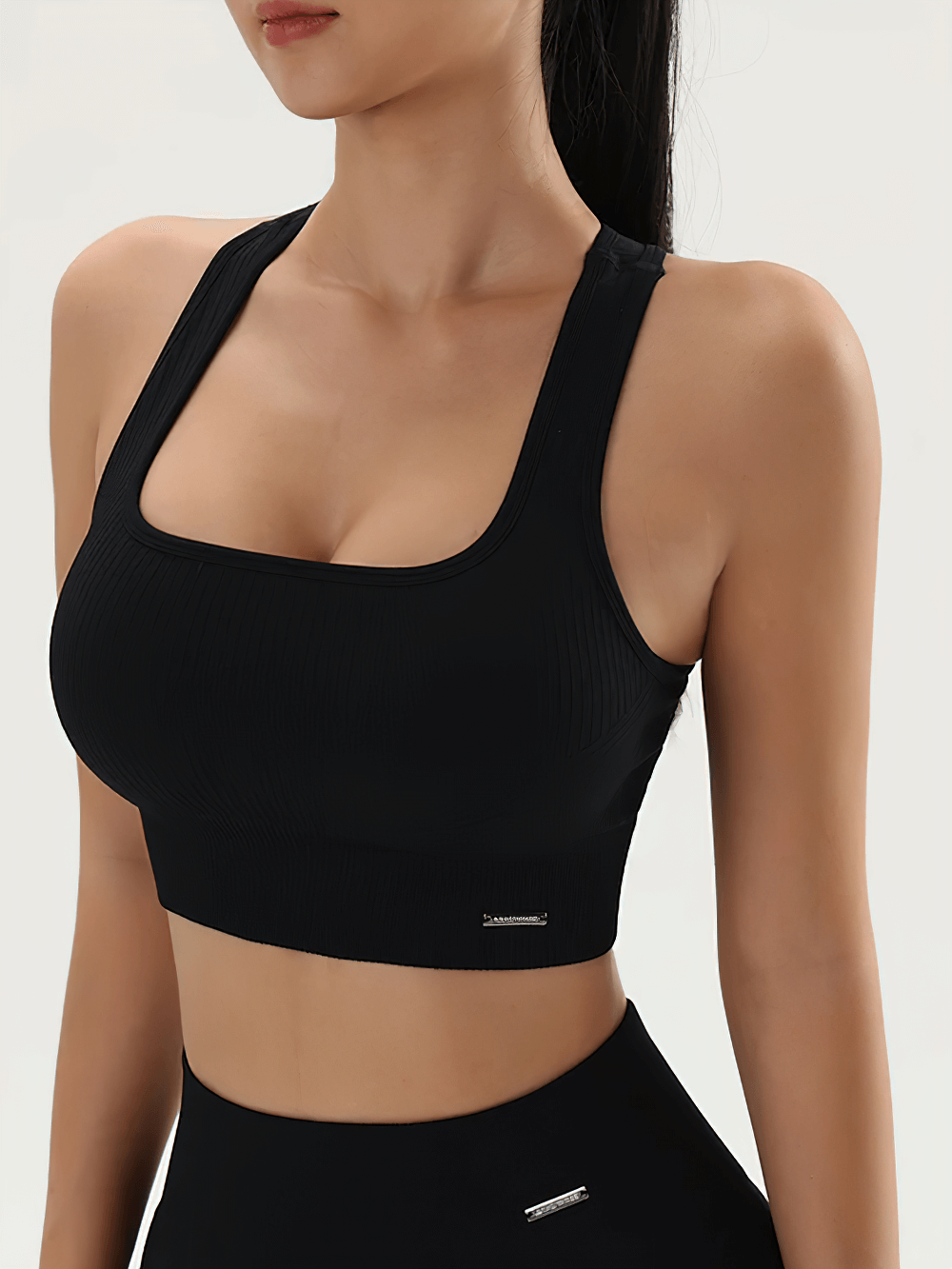 Woman wearing Seamless Ribbed Sports Bra with Racerback Support - SF4042 in black, ideal for yoga and gym workouts, showcasing front design.