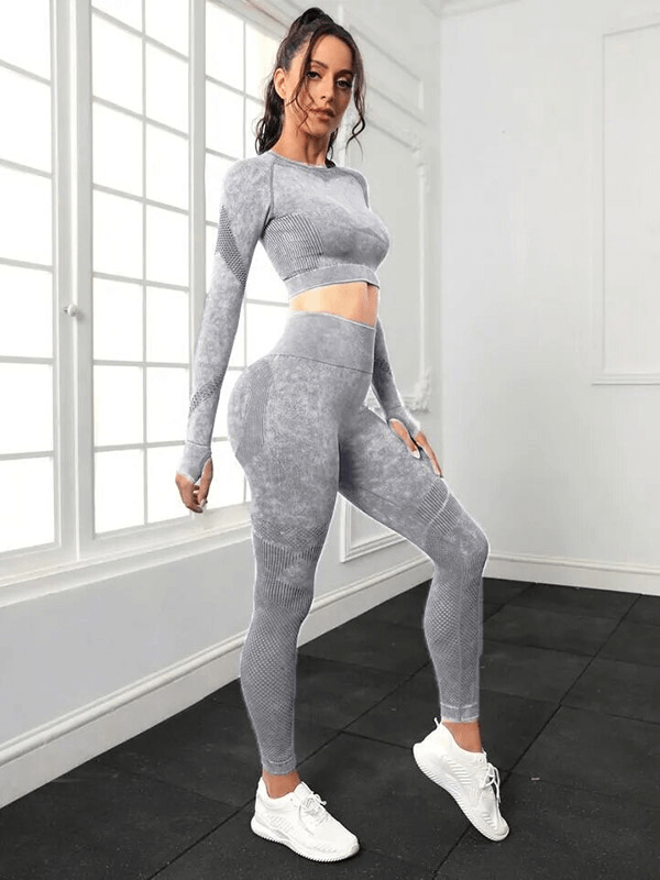 Woman wearing seamless high waist pants and long sleeved top in gray for yoga, featuring breathable and quick-dry tech.