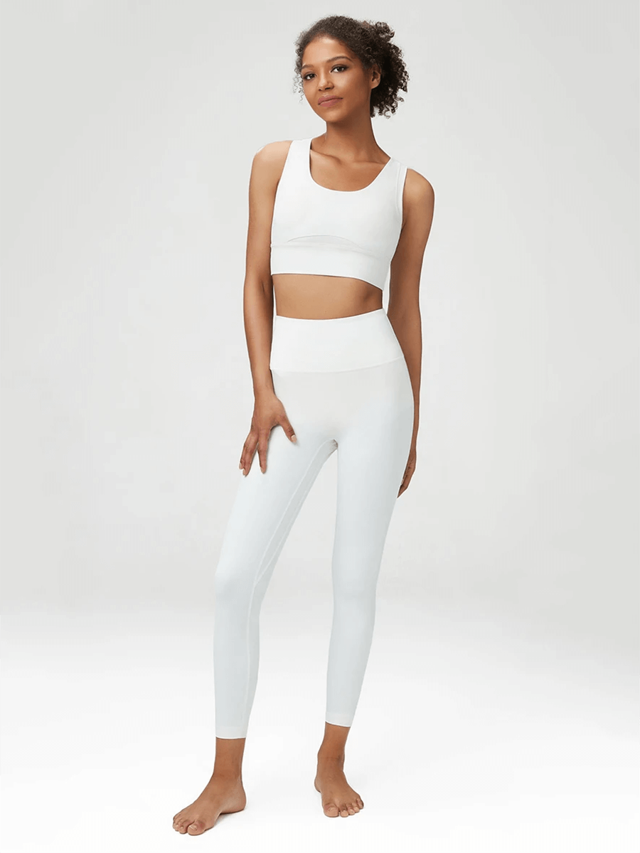 Woman wearing a seamless white yoga set designed for active women, featuring a sports bra and leggings for comfort and support.