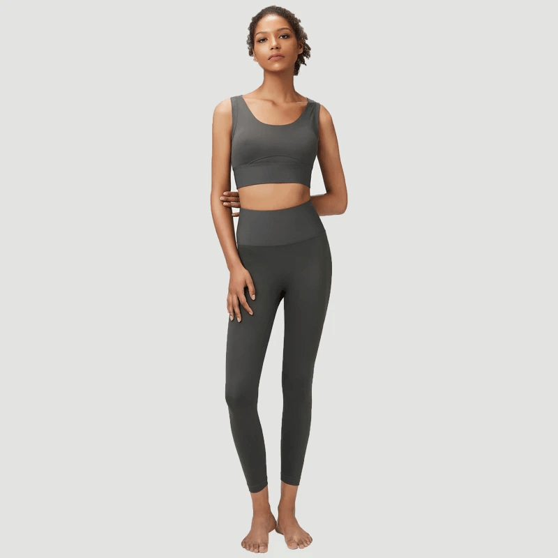 Woman wearing seamless yoga gear set in multiple shades, featuring a sleek sports bra and leggings, perfect for active workouts.