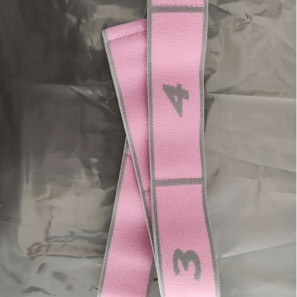 Pink segmented resistance strap for yoga and strength training, with numbered sections for adjustable stretching and flexibility.