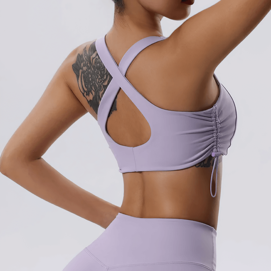 Woman in lavender adjustable sports bra with stylish crisscross back design, ideal for yoga and workouts.