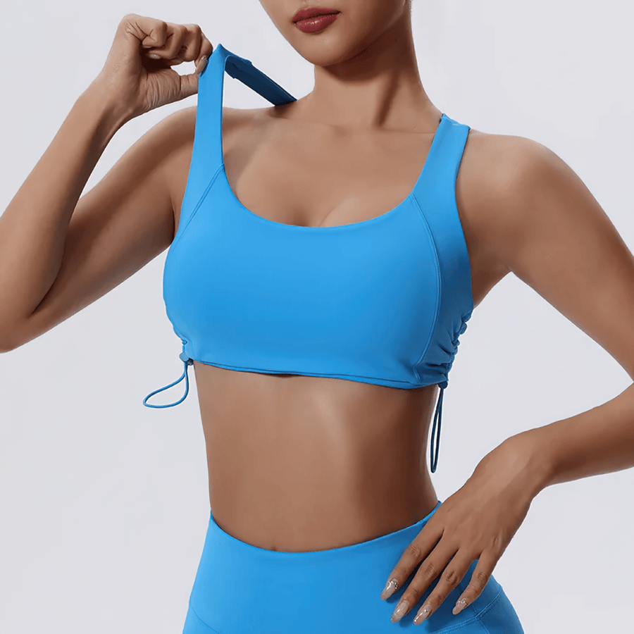Woman wearing a blue adjustable sports bra with a stylish, breathable design, ideal for fitness and yoga workouts.