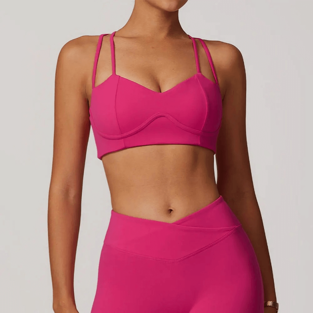 Women's sexy pink criss-cross strap sports bra for high support, perfect for gym, running, and yoga with breathable quick-dry fabric.