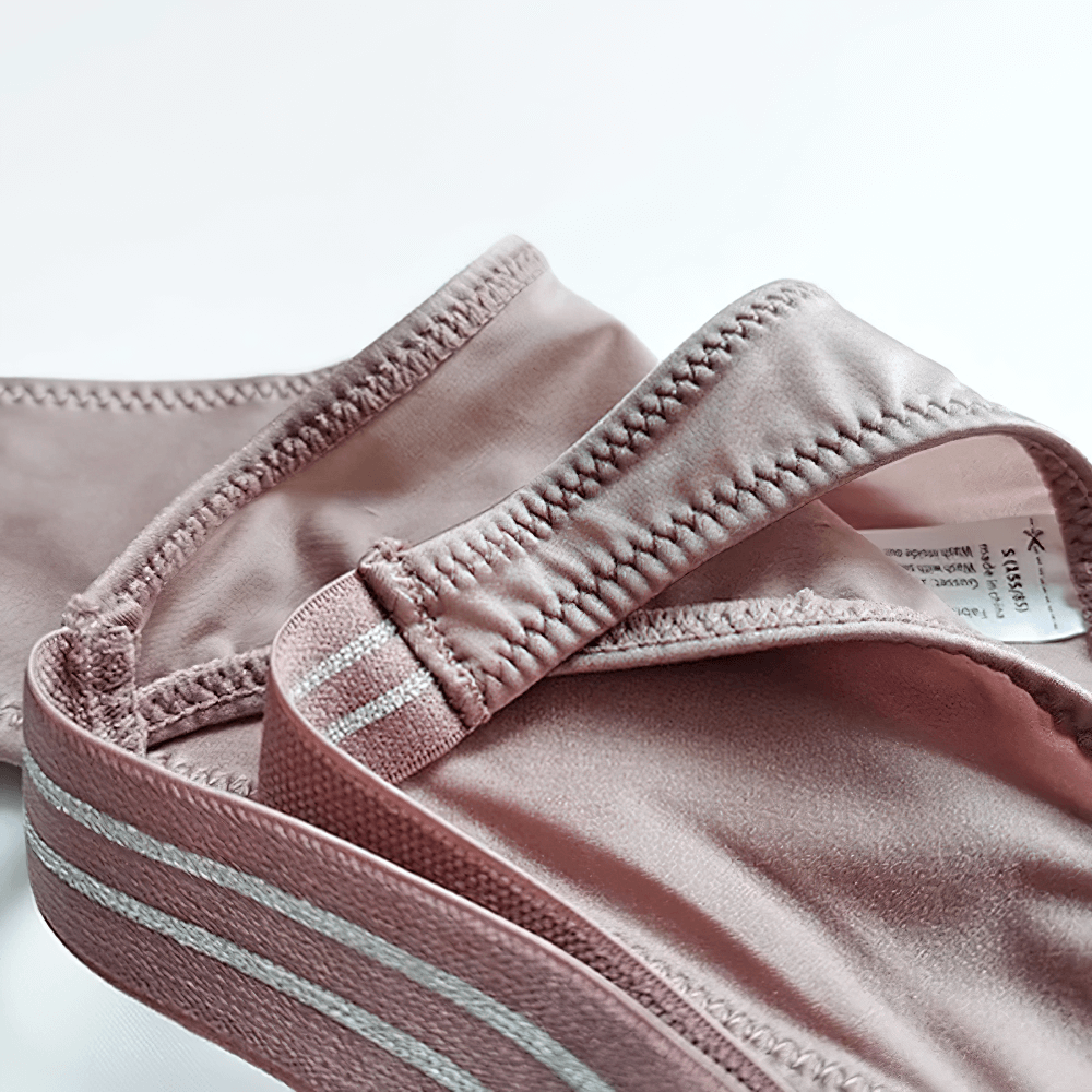 Pink low-rise G-string panties showcasing close-up of knit stitching and elastic waistband for a stylish, sleek look.