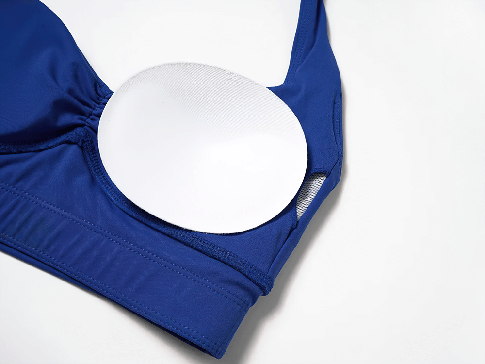 Blue racerback sports bra with removable padded cups, showcasing stylish athletic support for yoga and gym workouts.