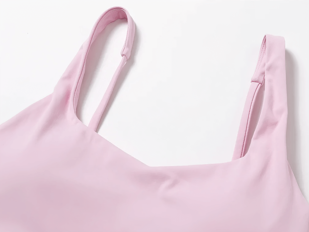 Close-up of a pink strappy sports bra with a square neckline, designed for yoga and fitness.