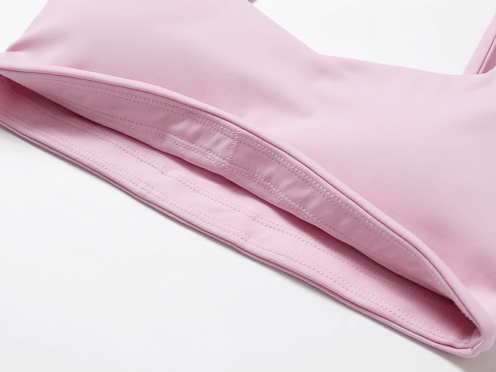 Close-up of pink strappy sports bra with square neckline, perfect for yoga and fitness with breathable, stretch fabric.