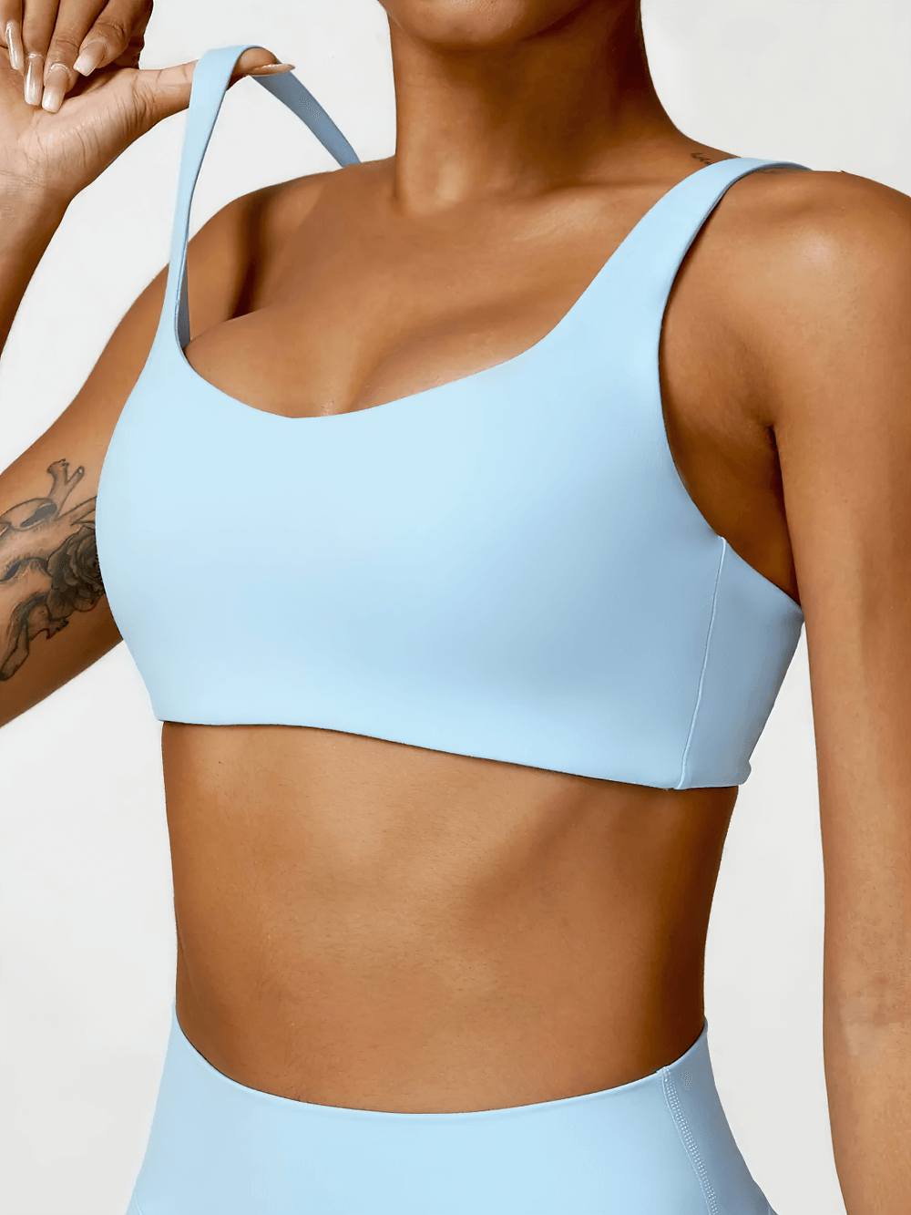 Stylish blue strappy sports bra with square neckline for yoga and fitness, offering medium support and breathable fabric for comfort.