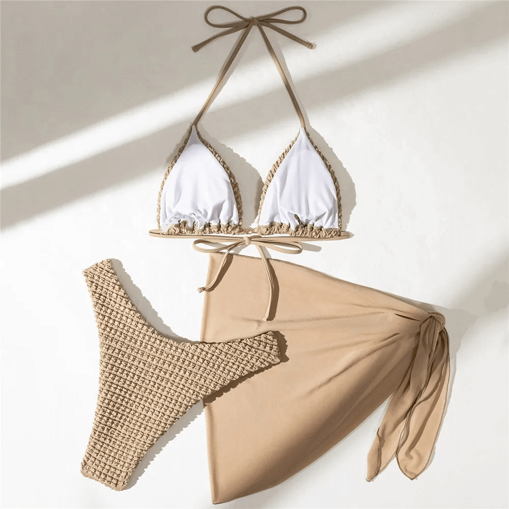 Neutral tones textured bikini set with halter top, cheeky bottom, and sarong. Perfect for stylish beach lounging. SKU: SF2139.