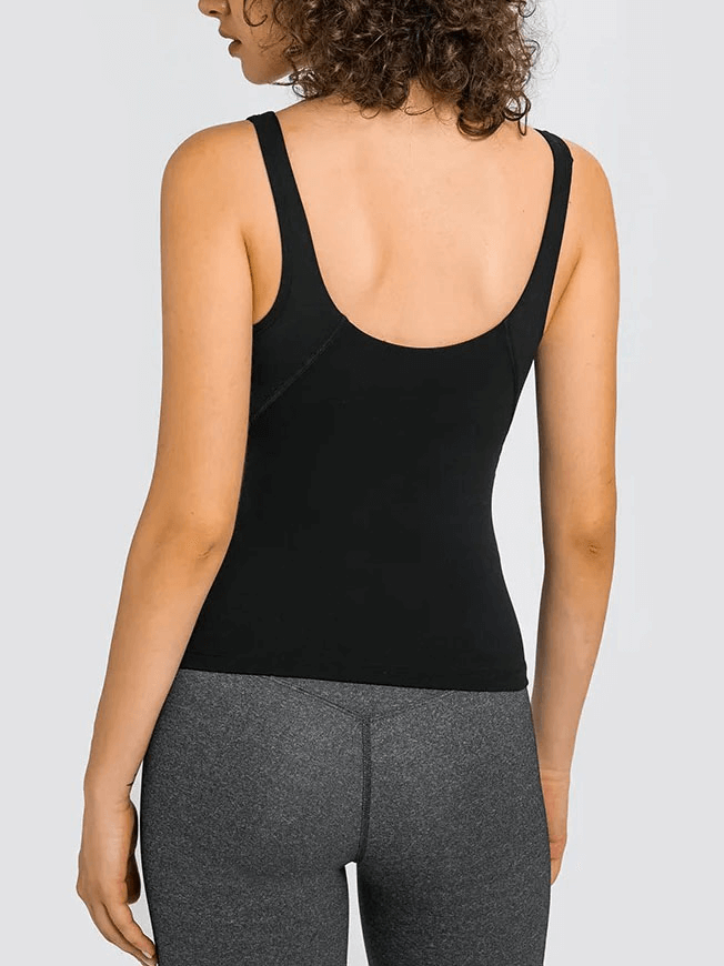 Back view of woman wearing black V-neck yoga sports tank top with padded bra, paired with grey leggings. Designed for comfort and flexibility.