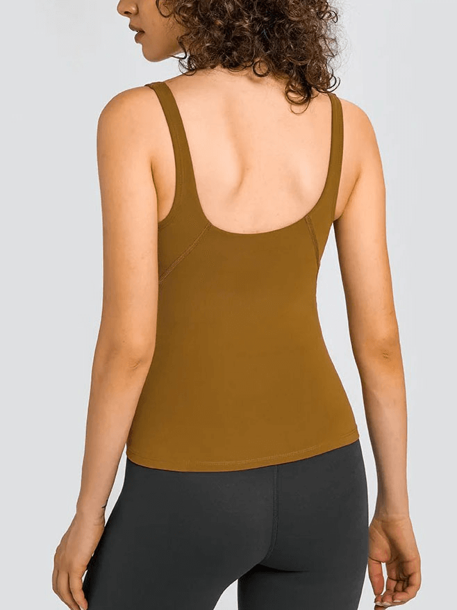 Back view of a woman wearing a brown V-neck yoga sports tank top with padded bras for flexibility and support in workouts.