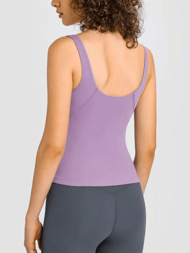 Back view of a woman wearing a sexy V-neck yoga sports tank top in purple, showcasing comfort and style, ideal for workouts.