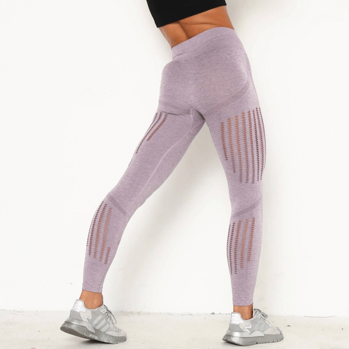 Woman wearing sexy high-waist seamless leggings in purple, highlighting the booty-lifting design and slim fit for casual style.