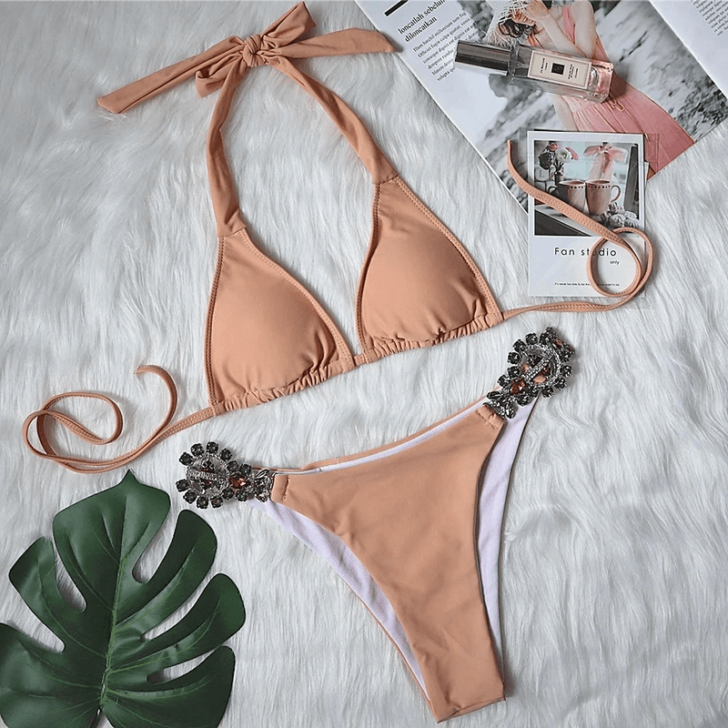 Sexy Women's Side Rhinestone Beach Bikini Set in peach with eye-catching rhinestone details and low waist cut, displayed on faux fur background.