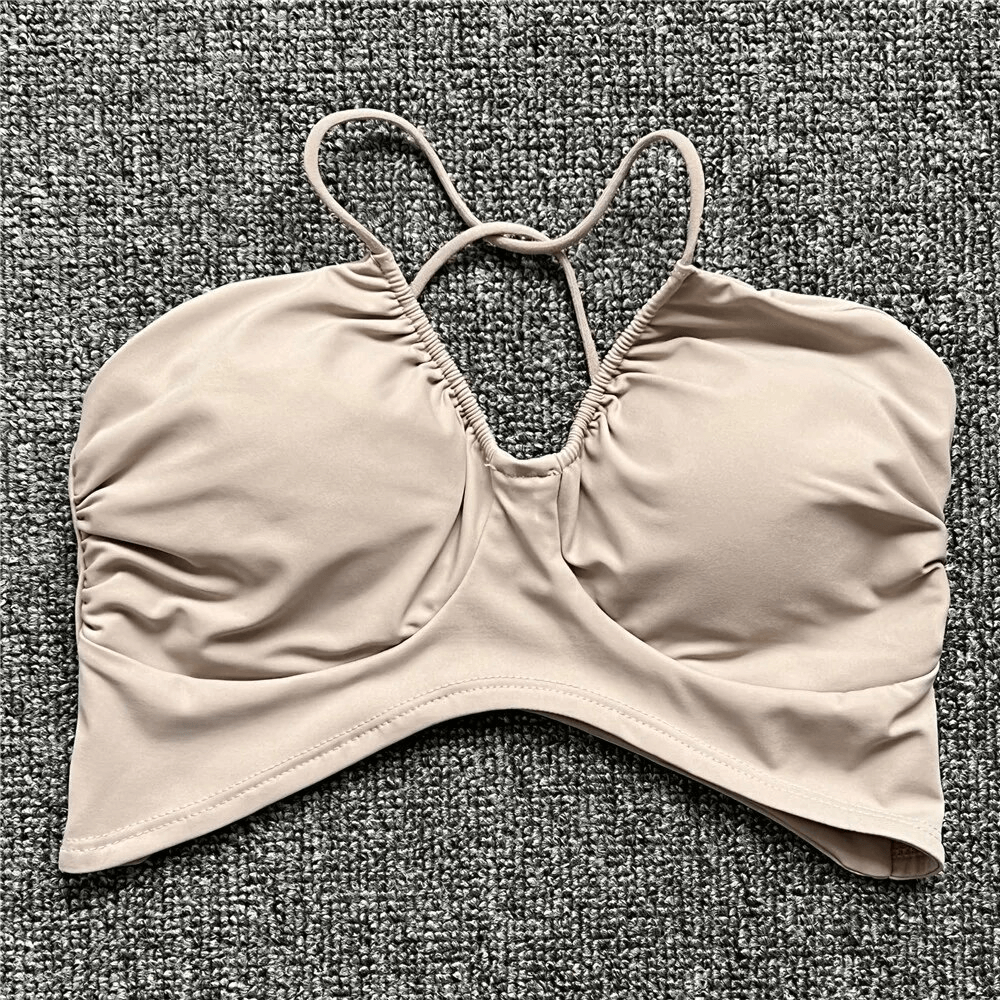 Tan women's sports bra with open back and deep neckline for running, made of polyester and spandex for superior elasticity.