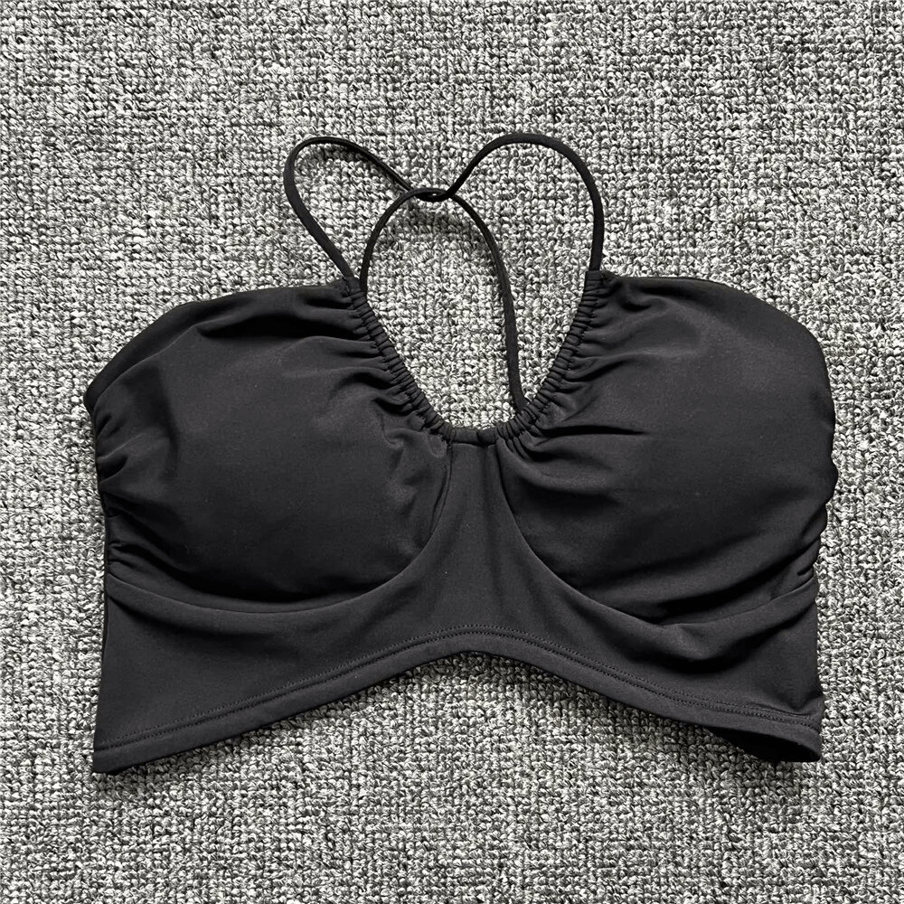 Sexy women's sports bra in black with open back and deep neckline, perfect for running and sports, made from polyester and spandex.