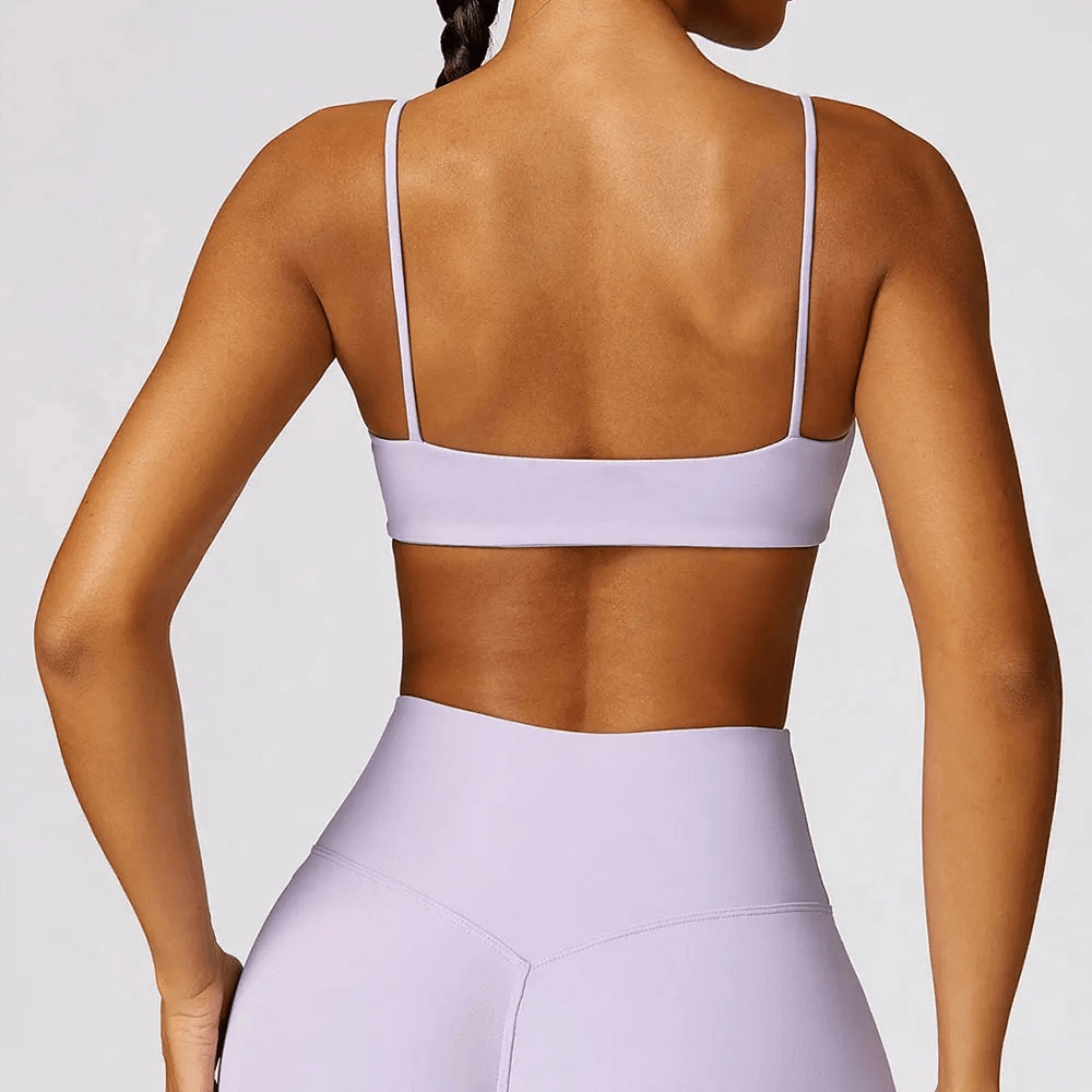Back view of woman wearing shockproof yoga sports bra in lilac, ideal for gym and fitness, showcasing breathable nylon-spandex design.