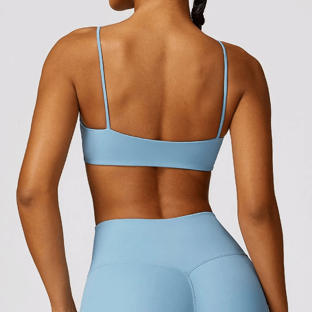 Back view of woman wearing shockproof yoga sports bra in light blue, showcasing its sleek, breathable design perfect for fitness and gym workouts.